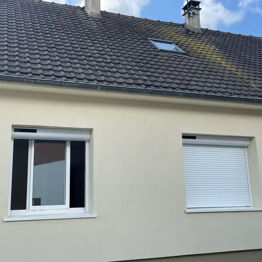Volets roulants blancs sur la façade d'un pavillon
